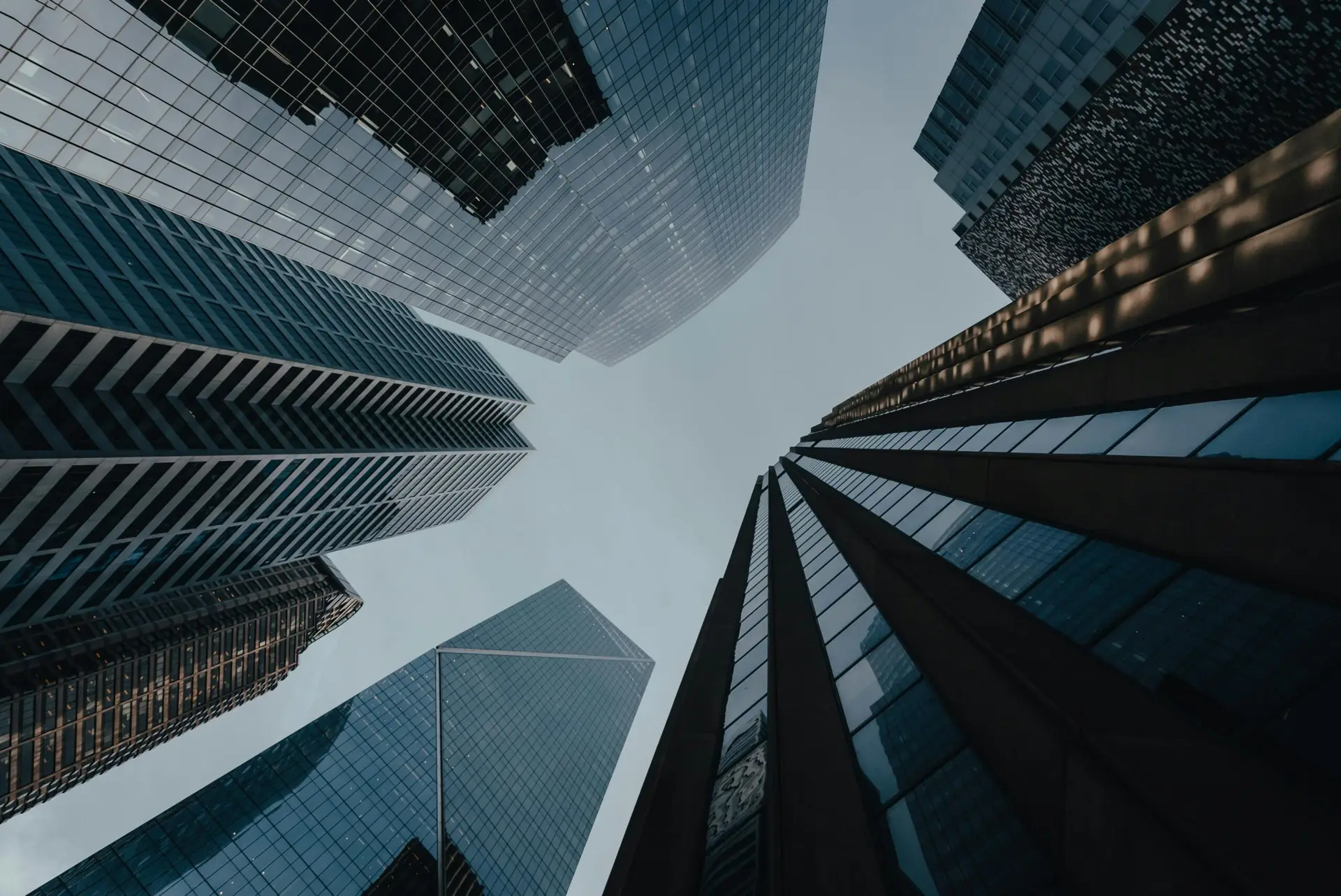 A dramatic upward view of modern skyscrapers creating a striking urban skyline.